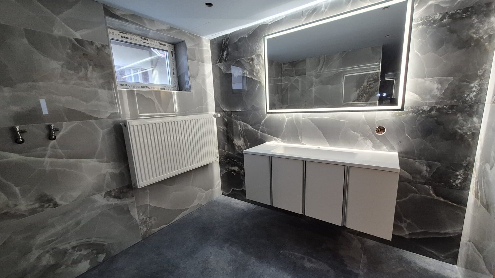 Modernes Badezimmer in Steinoptik mit LED-Spiegel