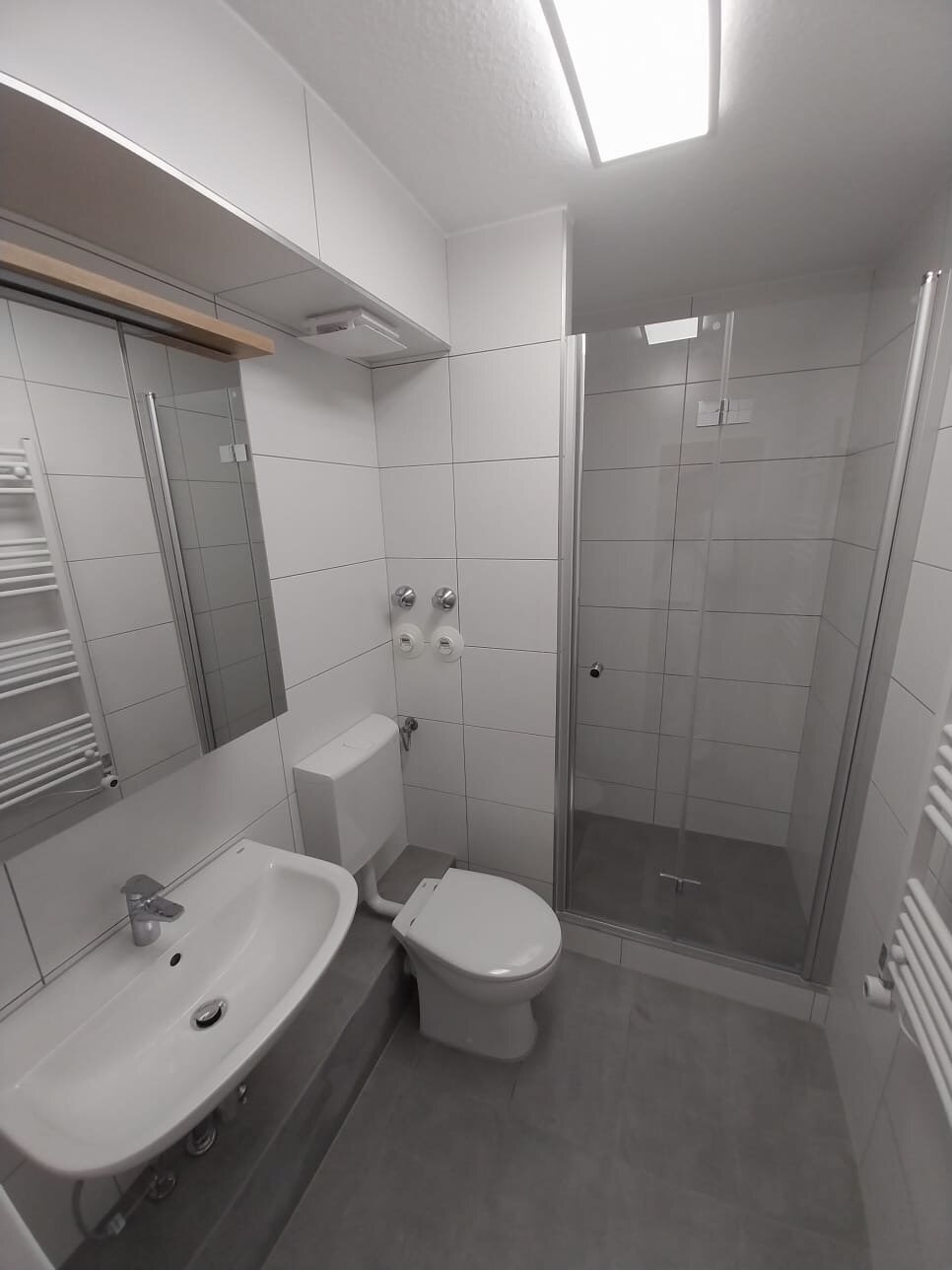 Hell gefliestes Badezimmer mit Dusche